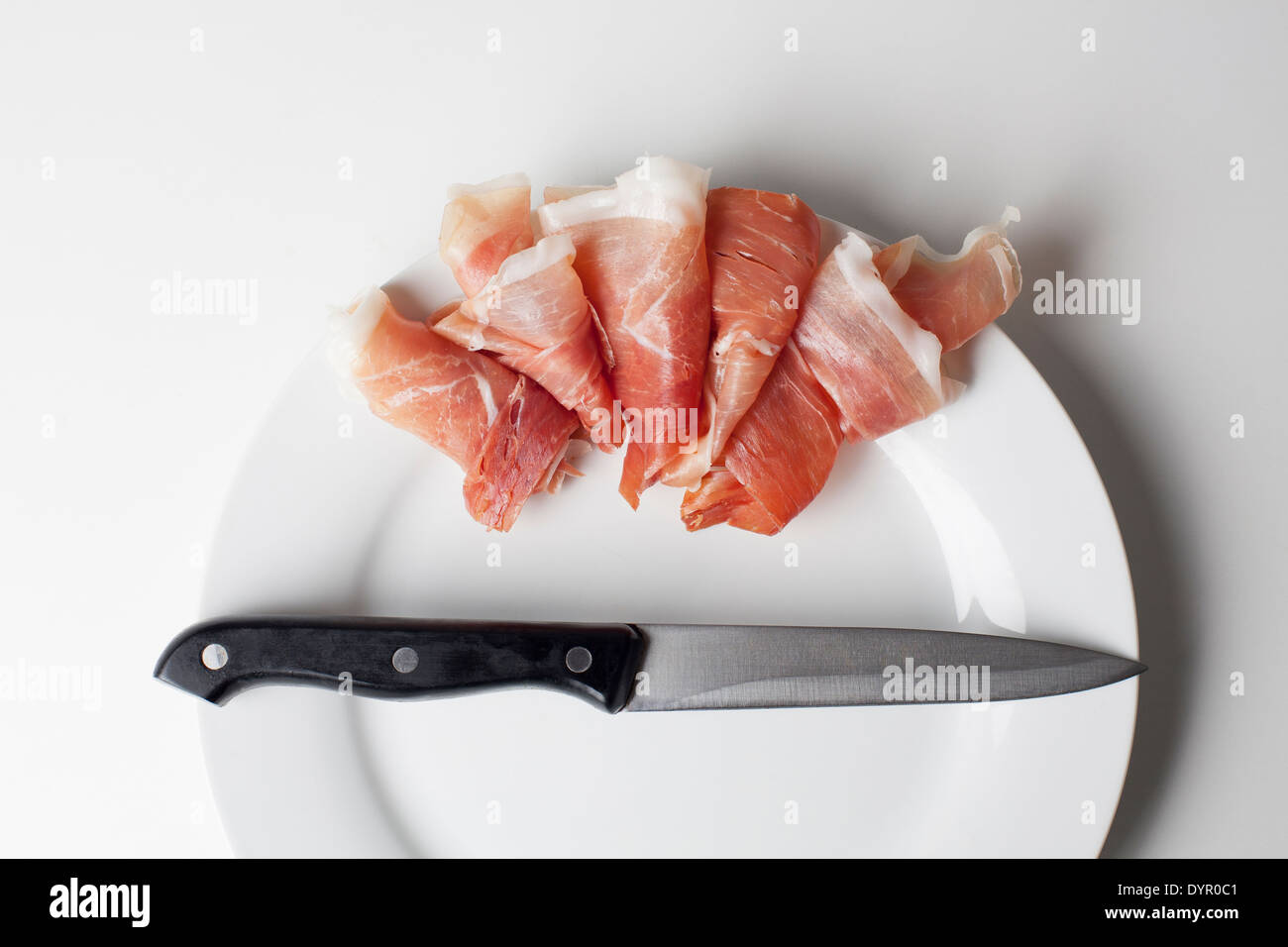 Prosciutto Spagnolo e un prosciutto su una piastra bianca Foto Stock