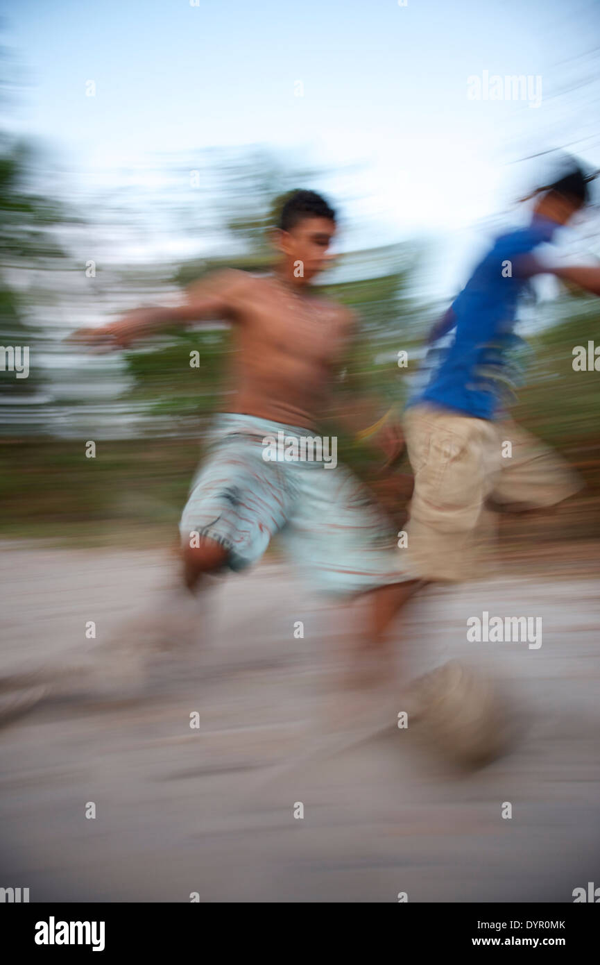 Il calcio brasiliano i giocatori di calcio in esecuzione sul passo di sabbia in una sfocatura in Nordeste Bahia Brasile Foto Stock