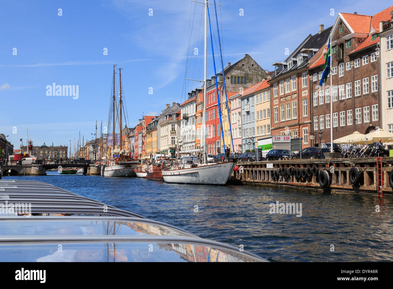I turisti canal sightseeing tour in barca passando di vecchi edifici in banchina a Nyhavn, Copenaghen, Zelanda, Danimarca, Europa Foto Stock