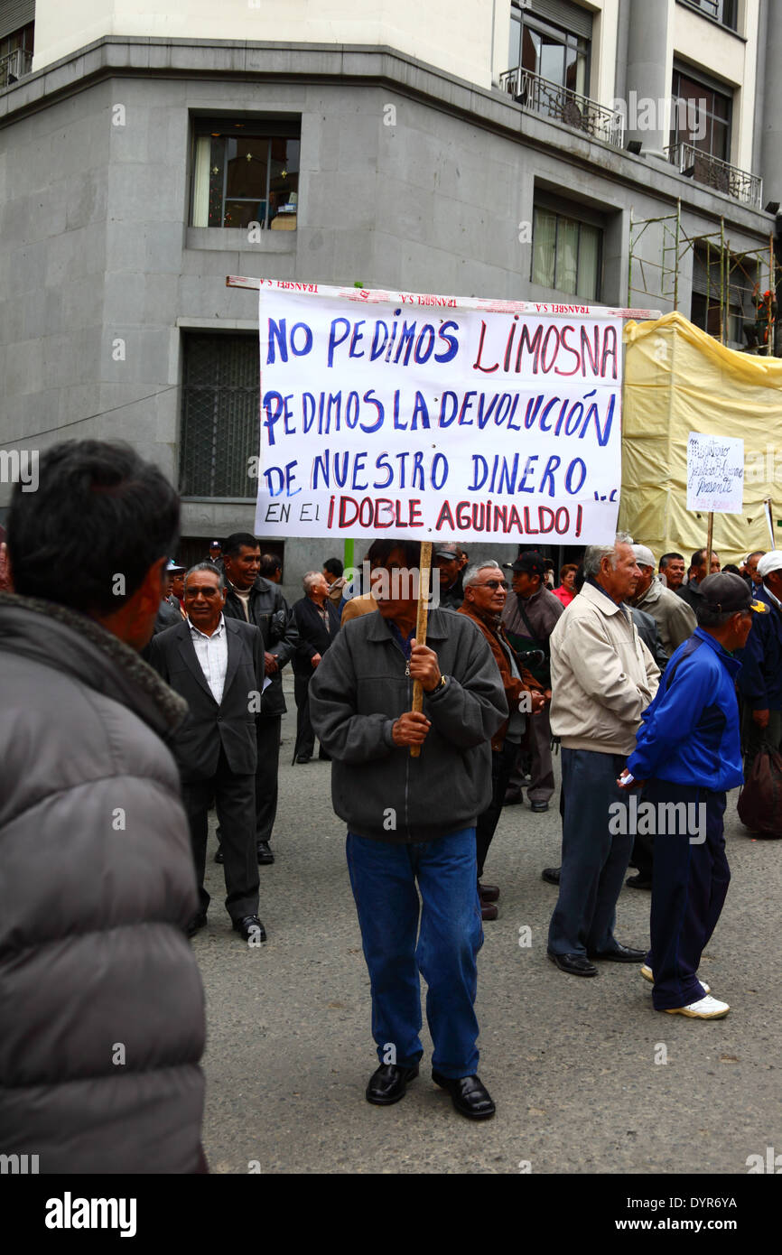 Un insegnante in pensione porta uno striscione durante una marcia di protesta chiedendo un aumento dei pagamenti pensionistici governativi per gli insegnanti, la Paz, Bolivia Foto Stock