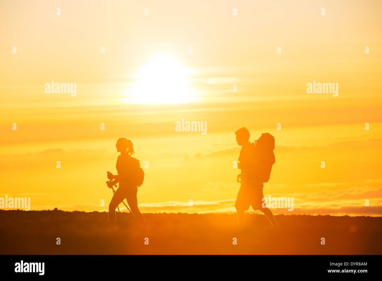 Gli escursionisti con zaini trekking sulla cima di una montagna al tramonto Foto Stock