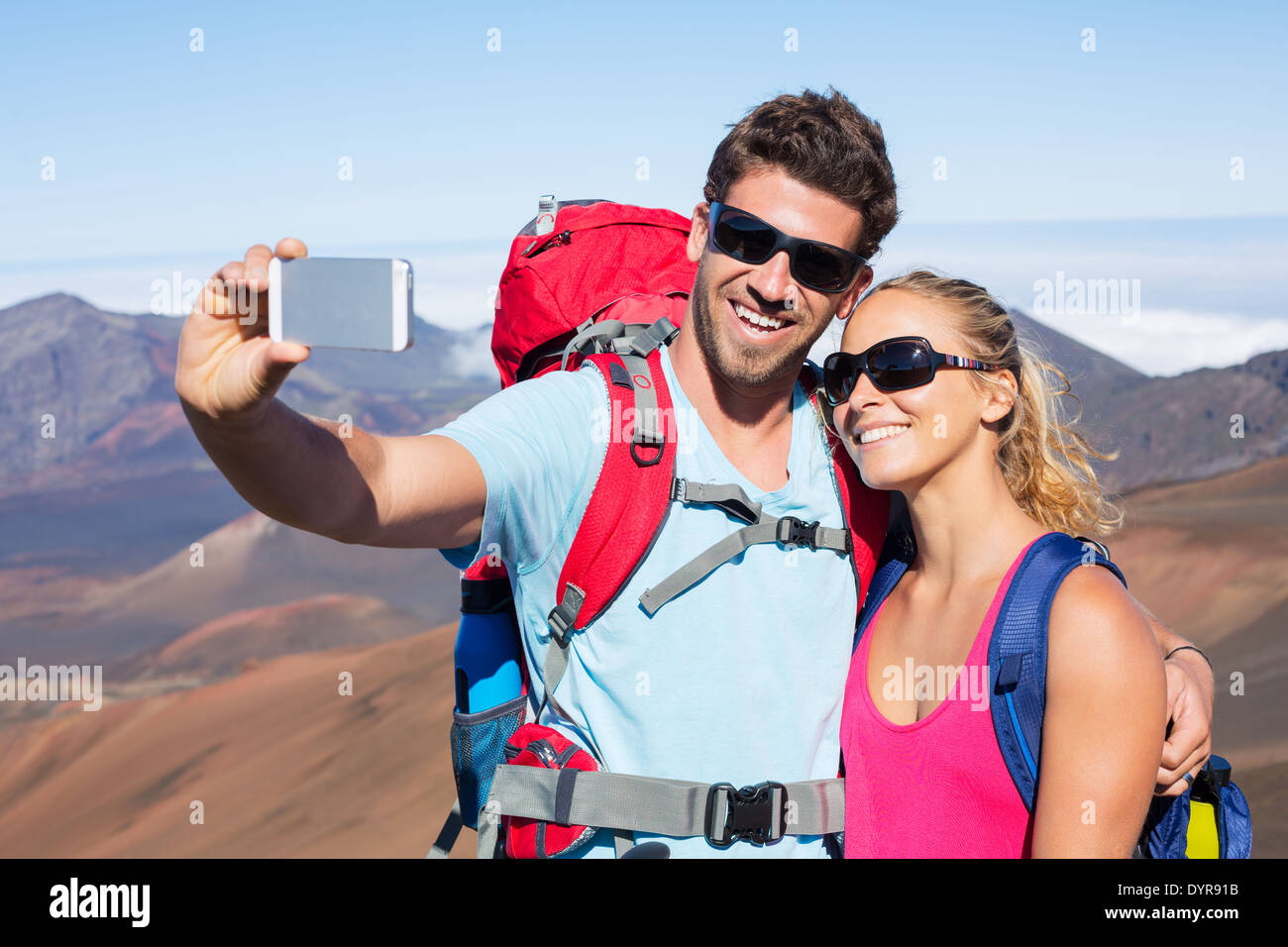 Coppia felice di prendere foto di se stessi con smart phone all'aperto, prendendo un 'selfie' Foto Stock