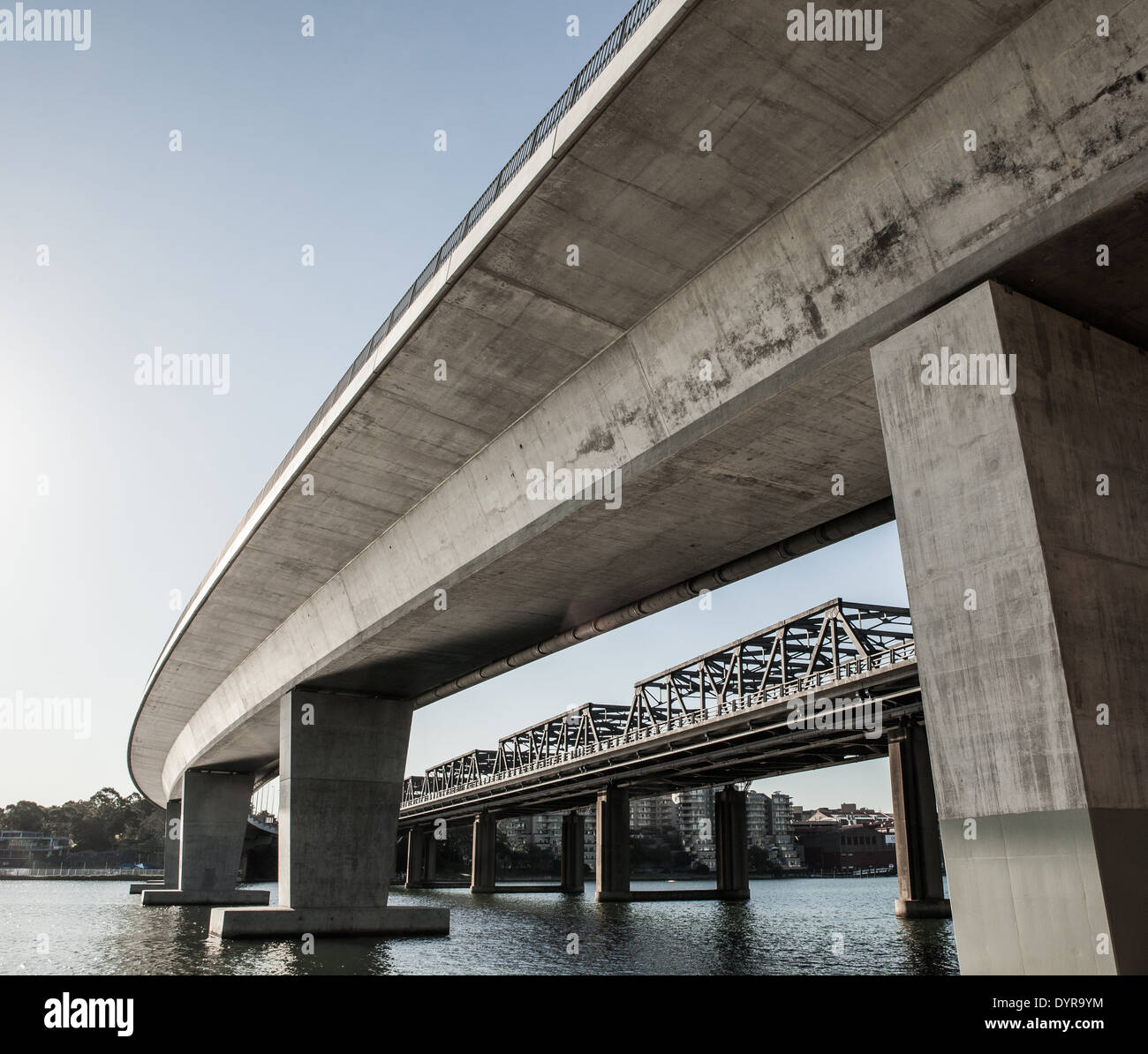 Un nuovo e un vecchio ponte che attraversa lo stesso tratto di acqua nel porto di Sydney Foto Stock