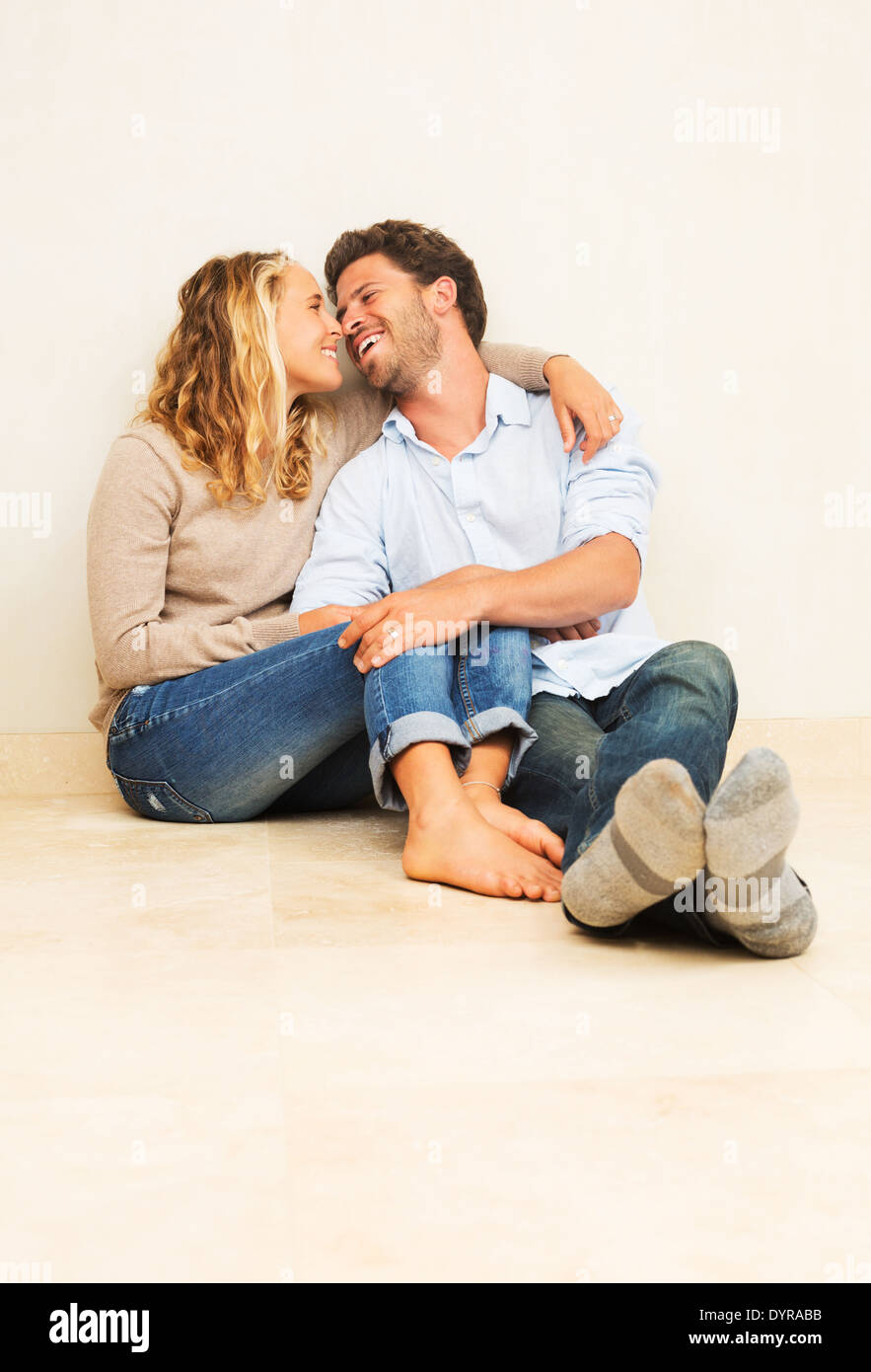 Felice coppia giovane a casa rilassarsi sul pavimento Foto Stock