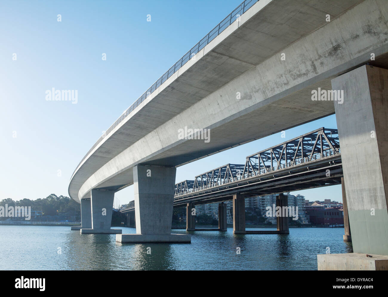 Un nuovo e un vecchio ponte che attraversa lo stesso tratto di acqua nel porto di Sydney Foto Stock