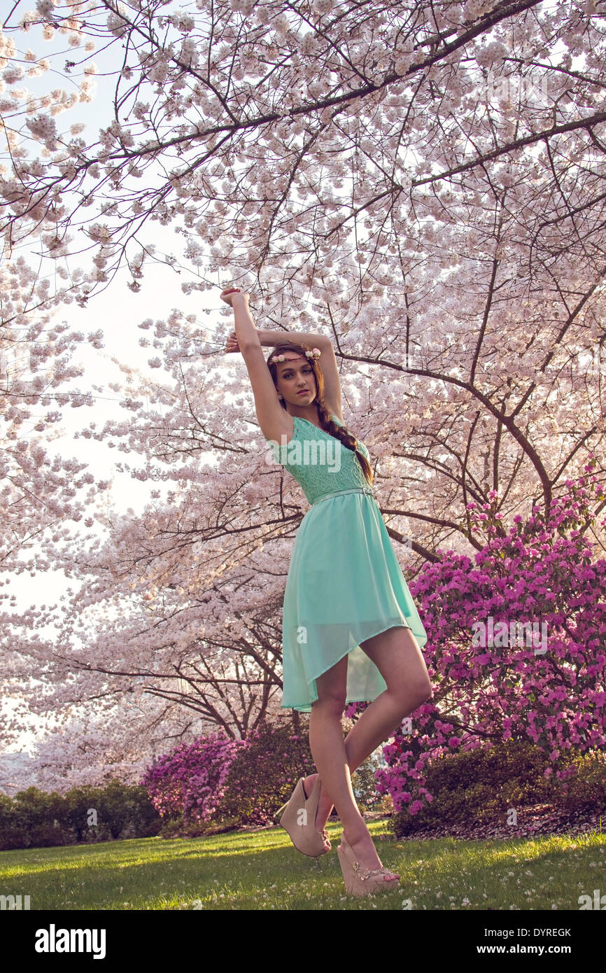 Bella giovane donna godendo di fioriture primaverili nel parco Foto Stock