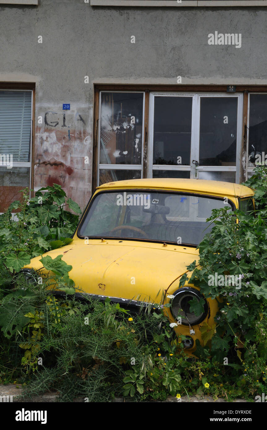 Giallo abbandonati mini auto al di fuori di un edificio abbandonato Lapta vicino Kyrinia Cipro del Nord Foto Stock