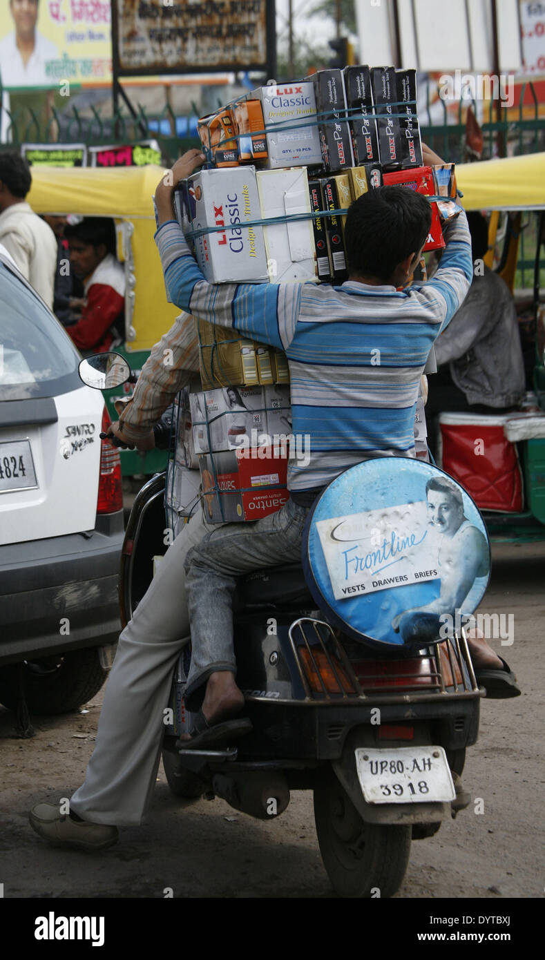 2 Gli uomini carichi di trasporto di merci su una motocicletta su una strada di Agra Foto Stock