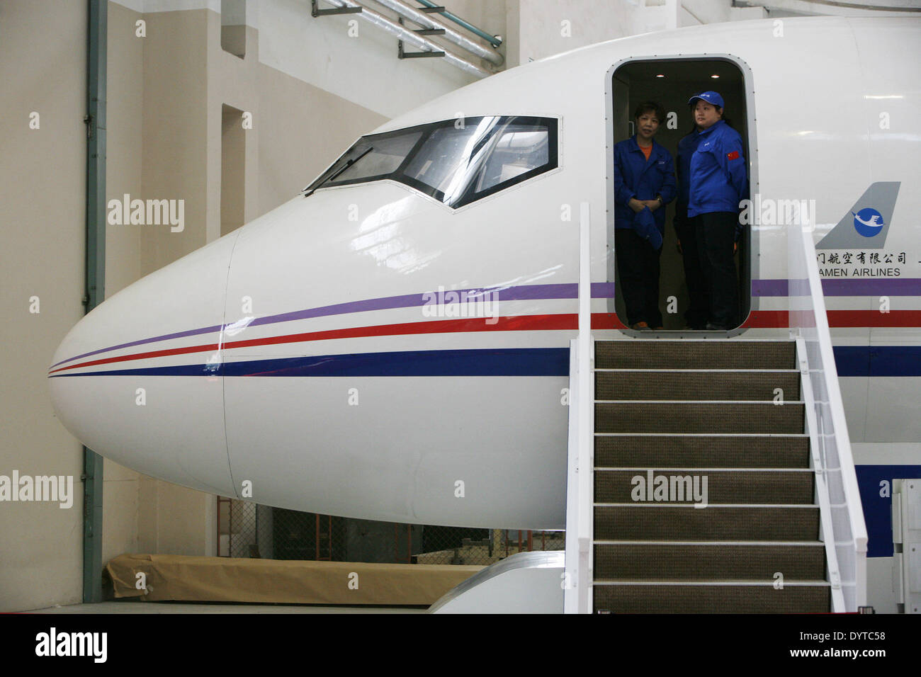 2 lavoratori cinesi stare alla porta di un ARJ 21 aeromobili commerciali modello presso un impianto di assemblaggio di Shanghai Foto Stock