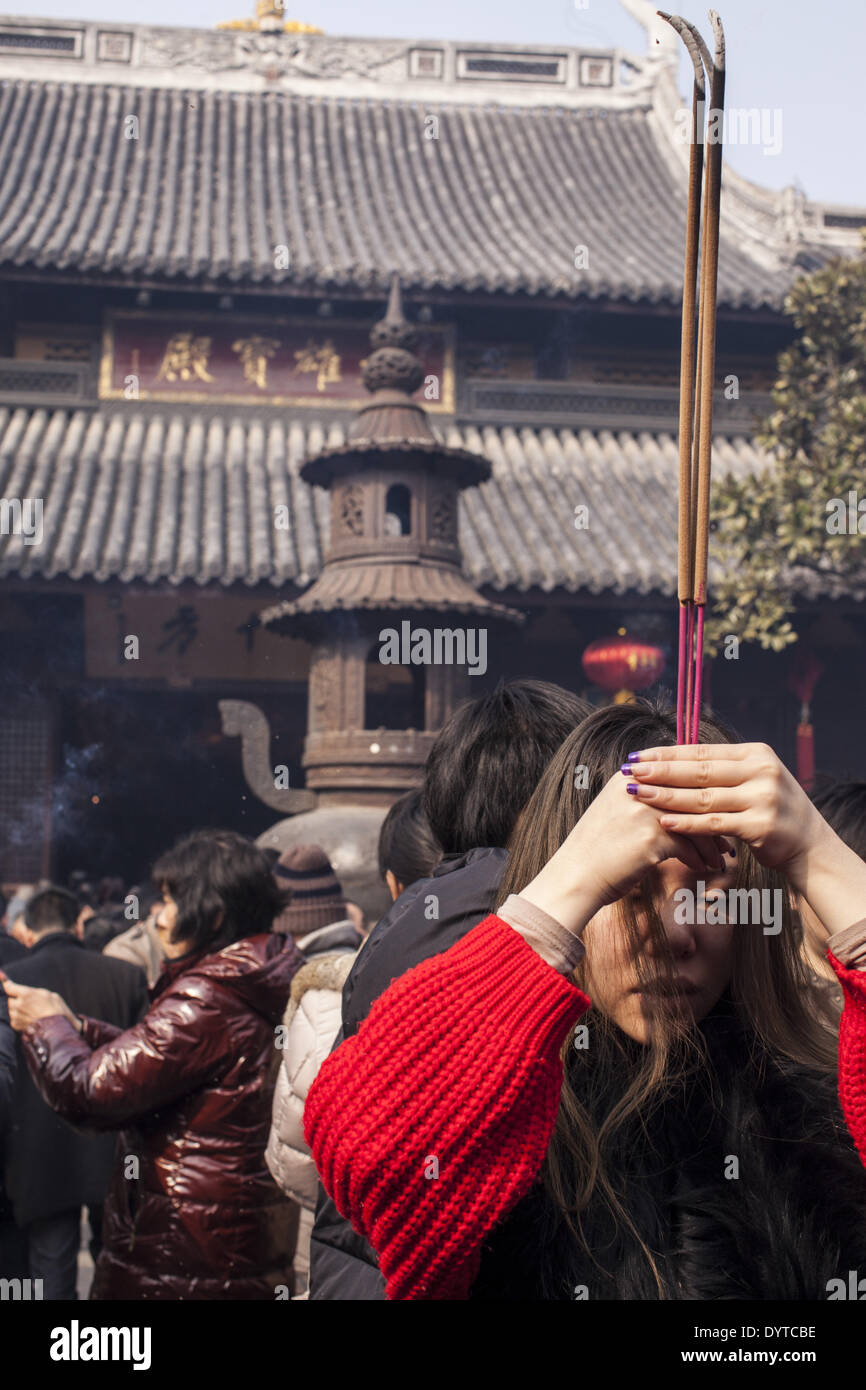 I fedeli pregano con bruciare incenso presso il tempio Longhua in Shanghai Foto Stock