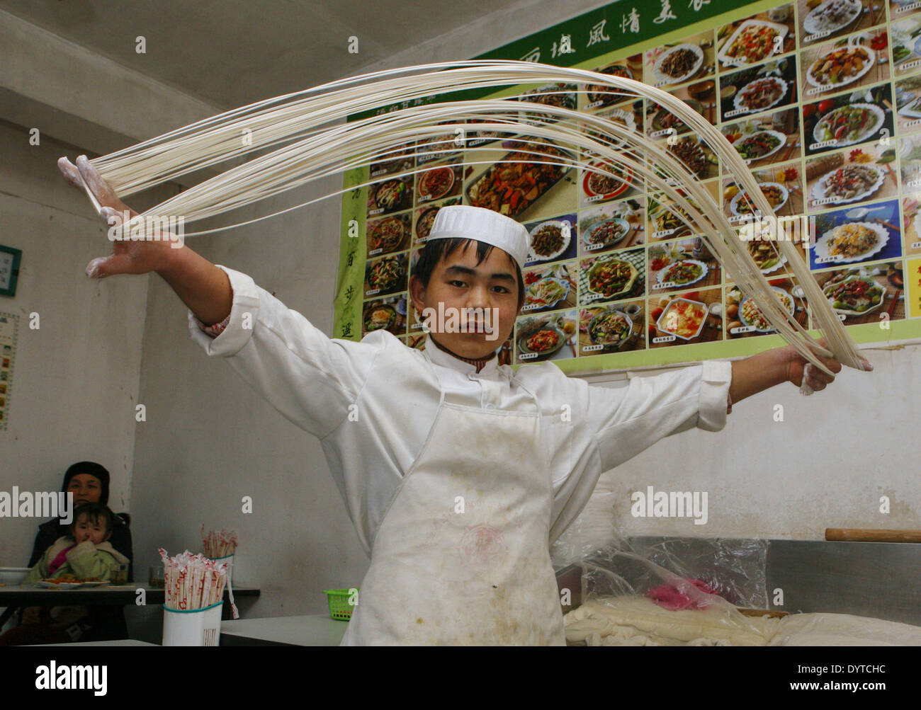 Un ragazzo musulmano rende noodle Foto Stock