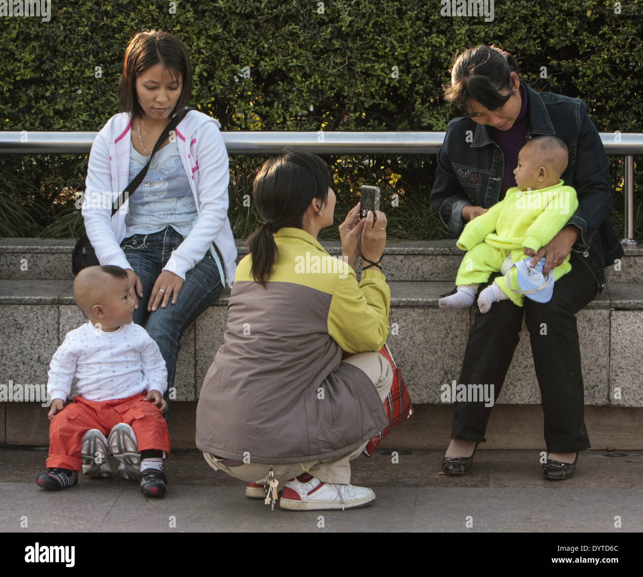 Una donna usa il suo cellulare per scattare una foto di un bambino al Bund Foto Stock