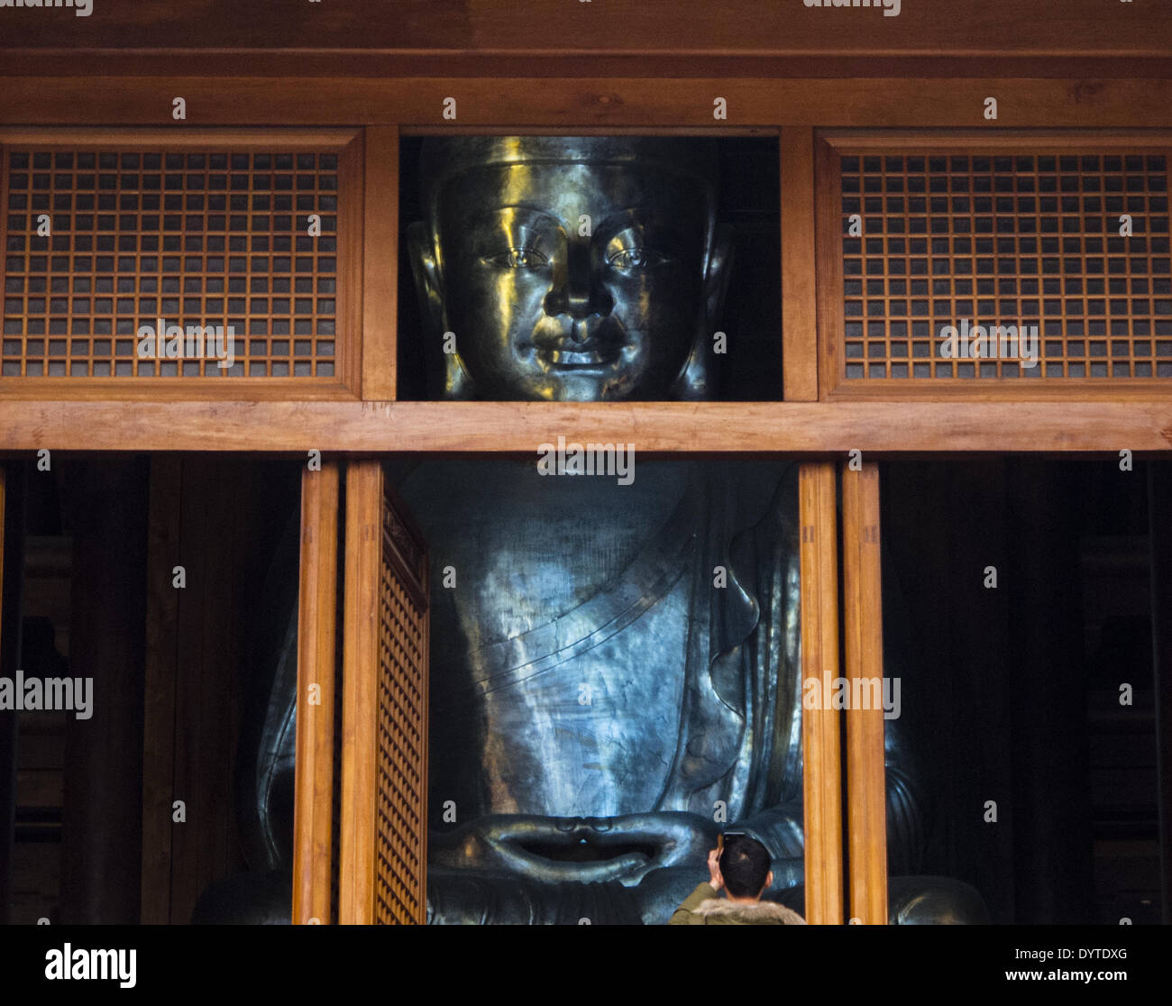 Un uomo di scattare una foto di un Buddha in Jingan Temple Foto Stock