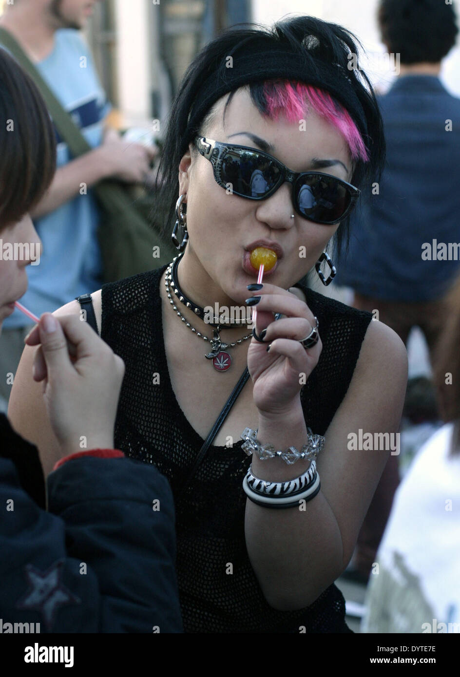 Un 22-anno-vecchia signora alla moda da Pechino mangia un lecca-lecca e gode di un momento di luce in corrispondenza di Midi Music Festival di Pechino Foto Stock