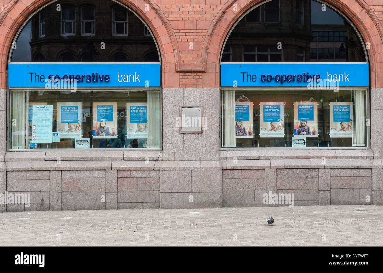 Un piccione solitario davanti ad una elevazione della Banca Co-Operative edificio nella zona centrale di Bradford, West Yorkshire, Regno Unito. Foto Stock