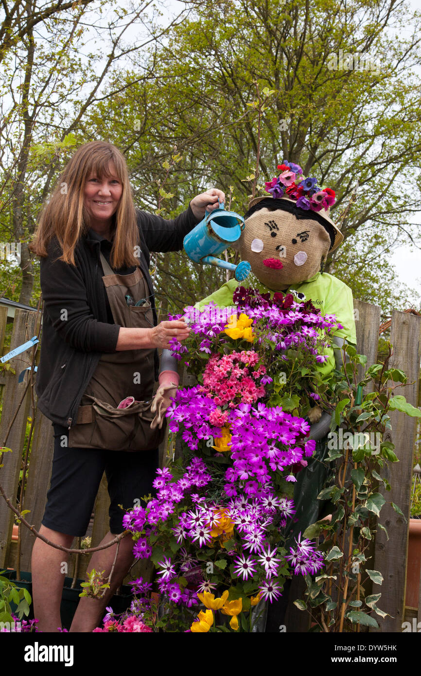 La sig.ra Ann Winnery annaffiava la sua esposizione mentre si preparano per il Wray Scarecrow Festival, con il tema "Heroes & Villains" che apre sabato 26 aprile 2014 per una parata di Scarecrow. Foto Stock