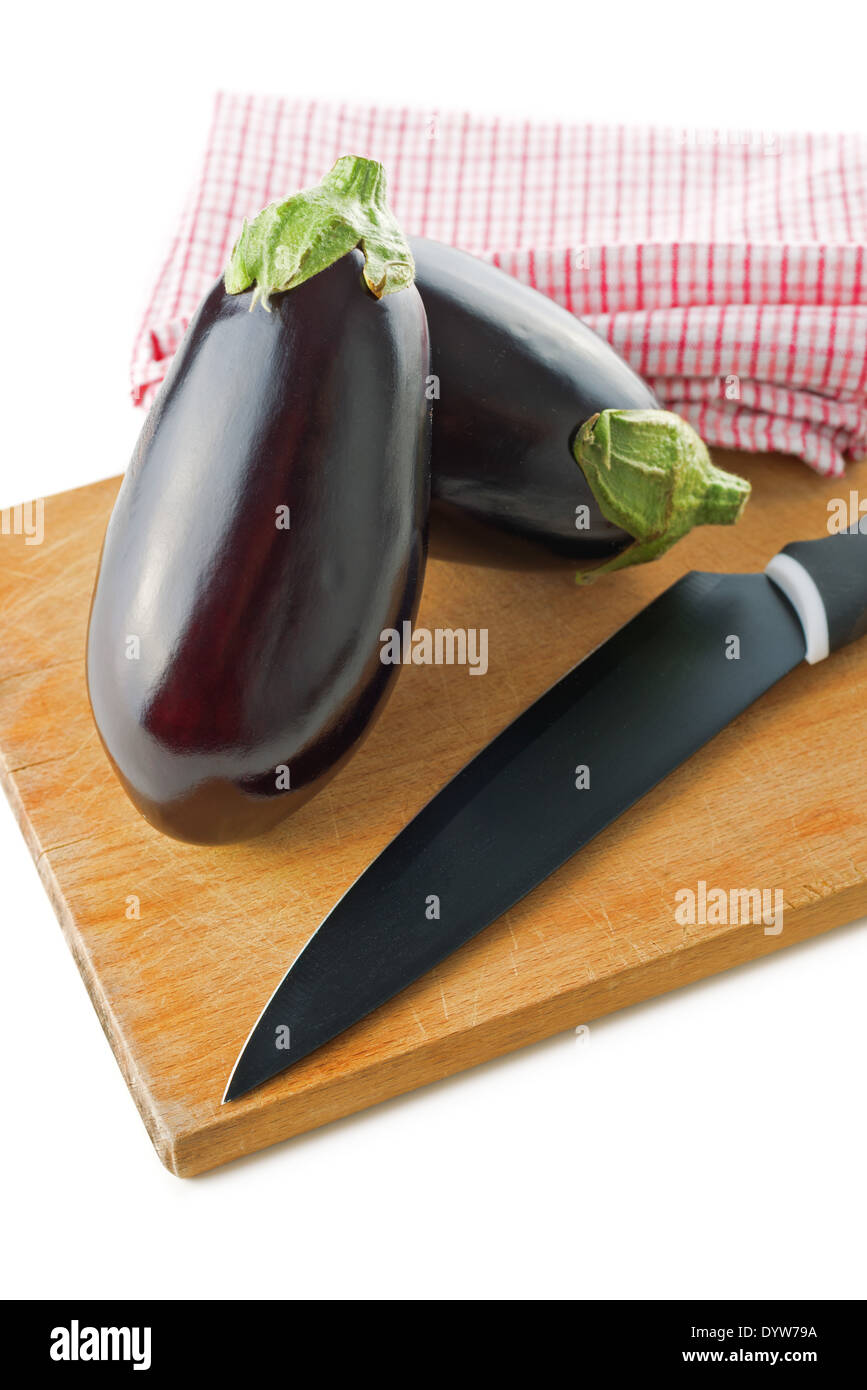 Le melanzane o melanzane con coltello su legno scheda chop. Questo vegetale è anche noto come melongene, giardino uovo o guinea squash. Foto Stock