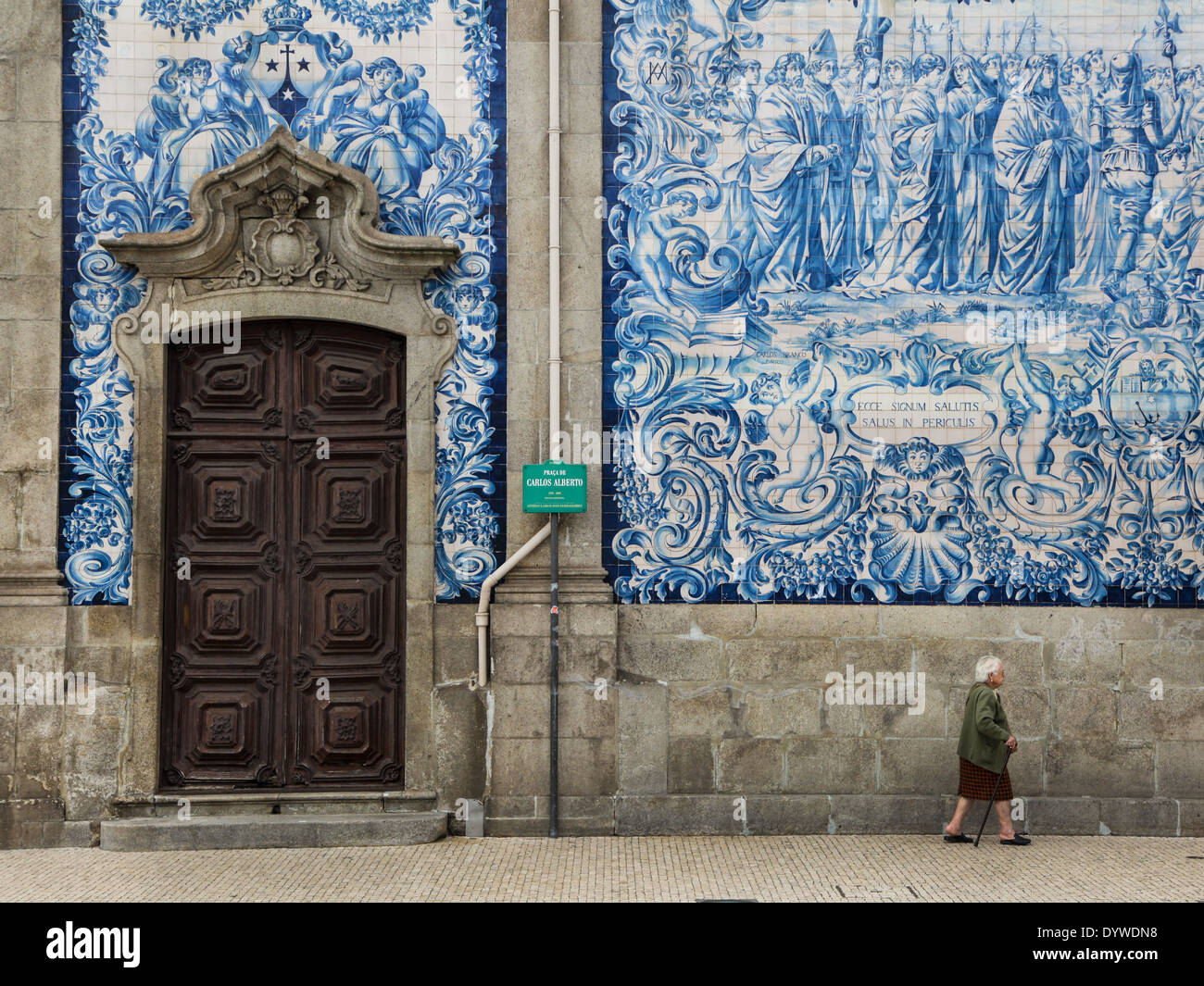 Donna che cammina accanto alla parete di Azulejo in porto Foto Stock