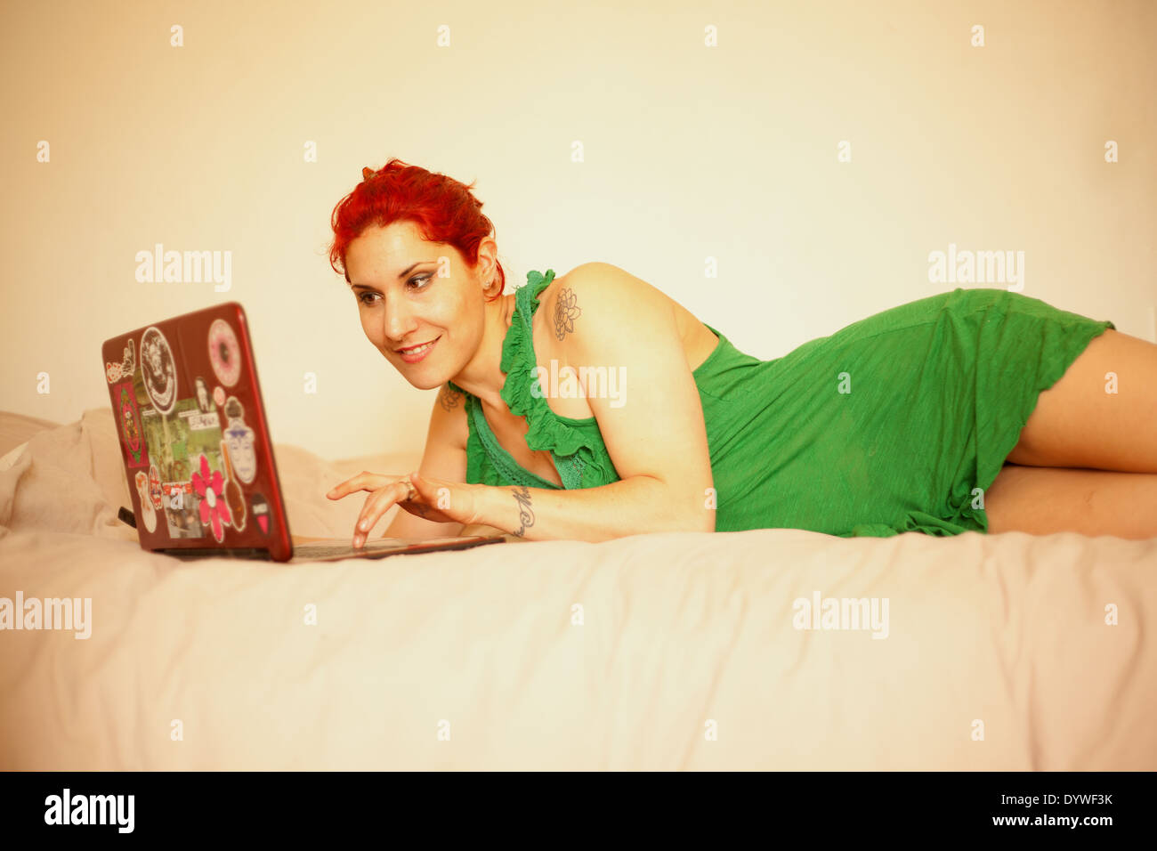 Donna con notebook sul suo letto. Foto Stock