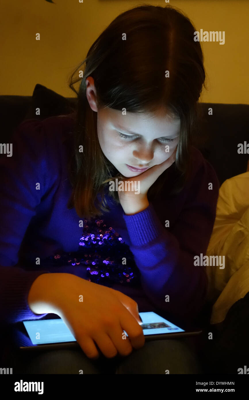 Berlino, Germania, bambina guarda al buio sul loro tablet PC Foto Stock