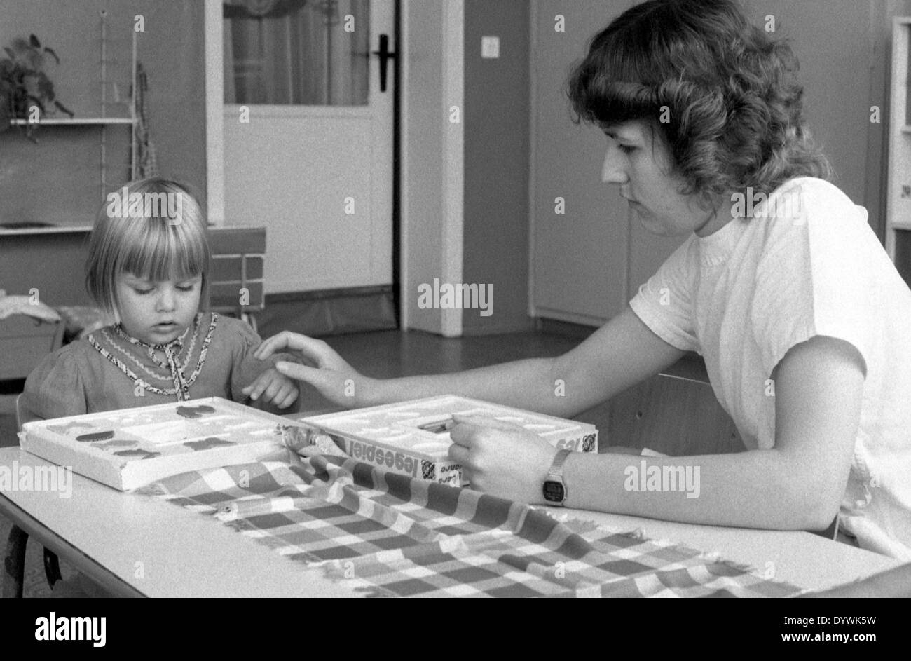 Berlino, DDR, educatori a giocare con una bambina di un gioco di posizionamento Foto Stock