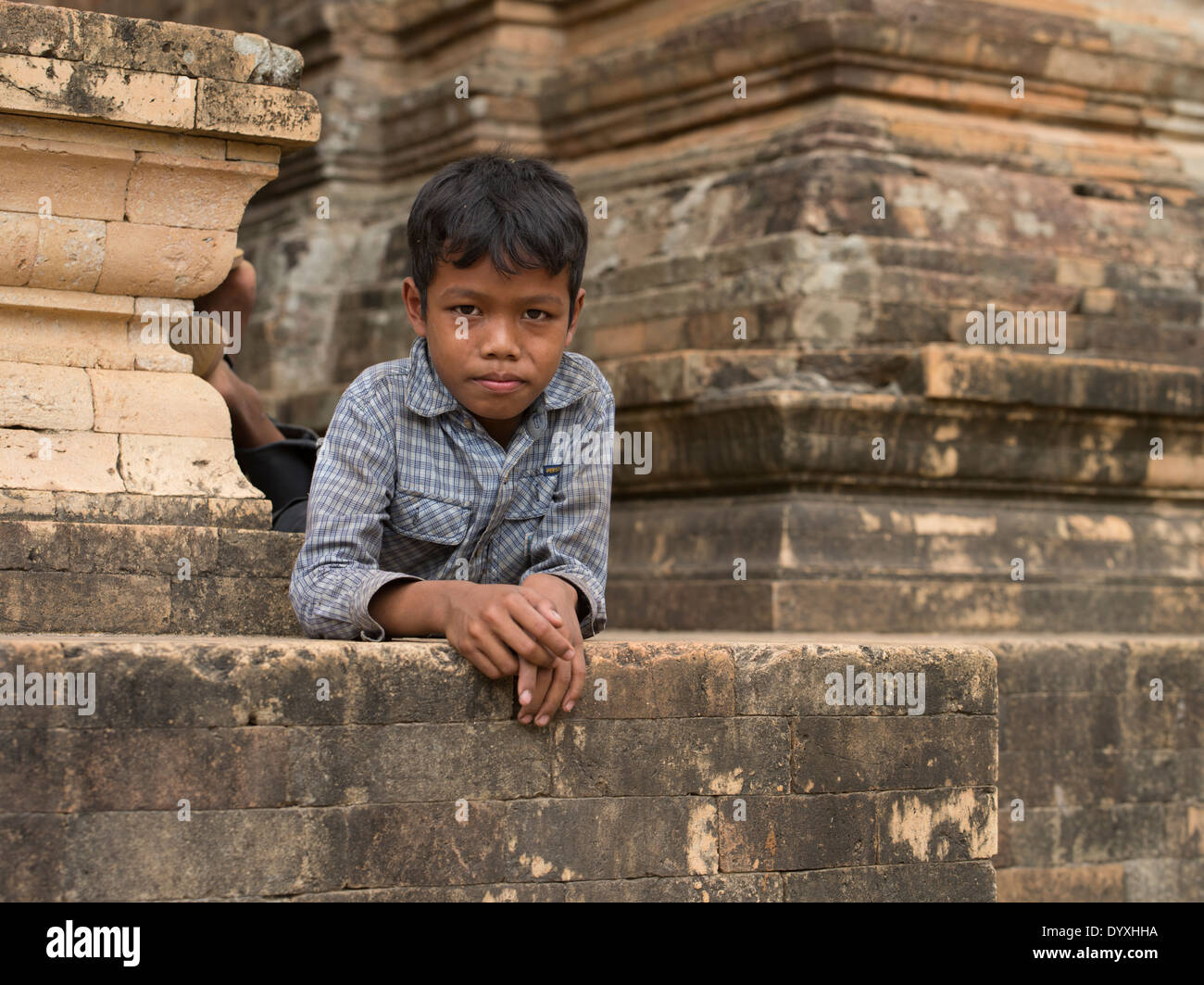 Giovane ragazzo cambogiano appendere fuori a Prasat Kravan un tempio indù costruito in mattoni. Siem Reap, Cambogia Foto Stock