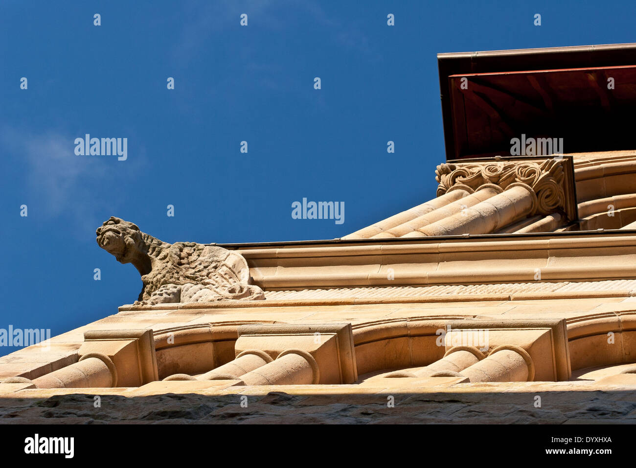 Guardando verso l'alto un forte angolo al lato della chiesa con golden colonne di arenaria & gargoyle Foto Stock