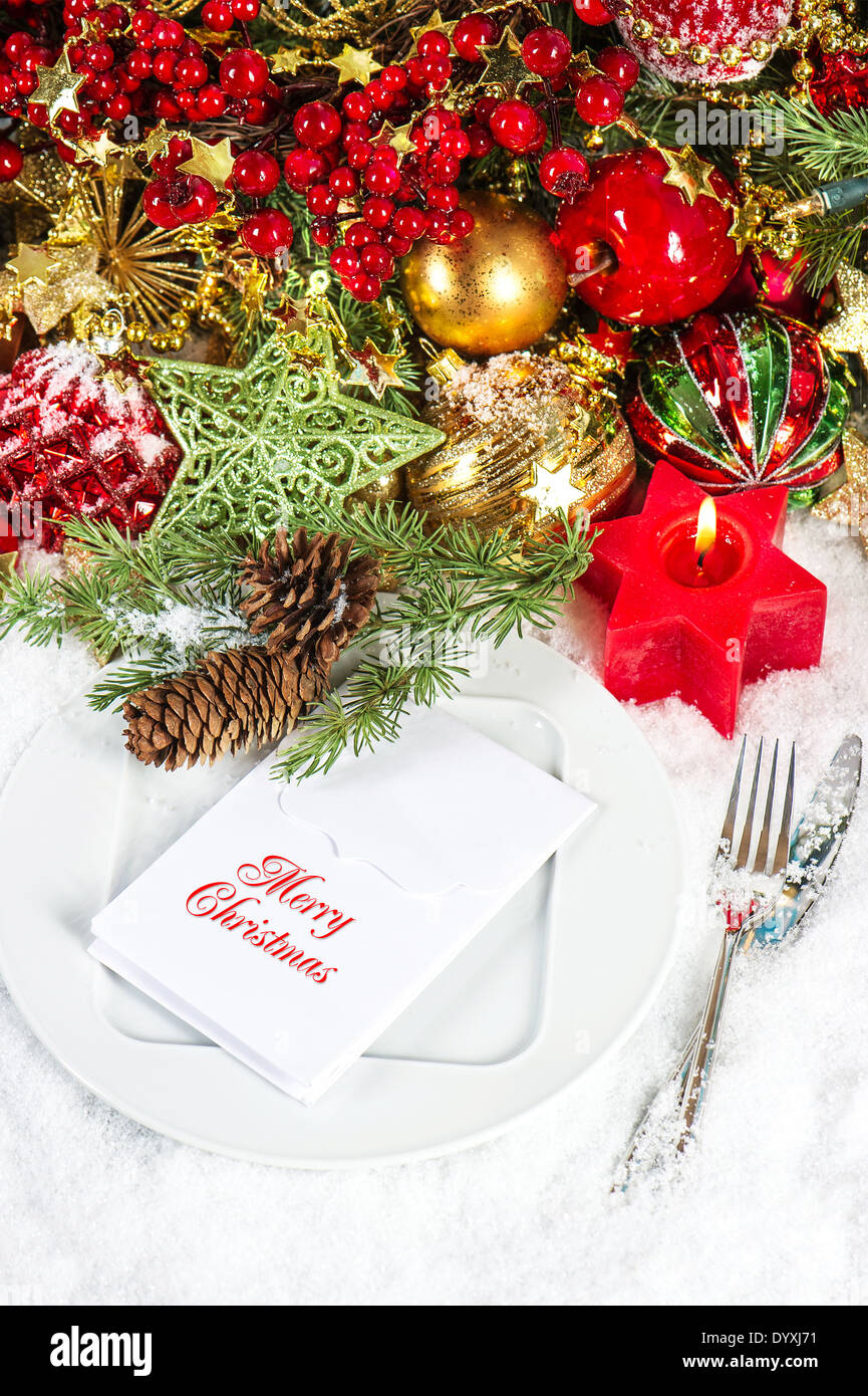 Natale posto tavola decorazione di impostazione in rosso e oro. Cena a lume di candela Foto Stock