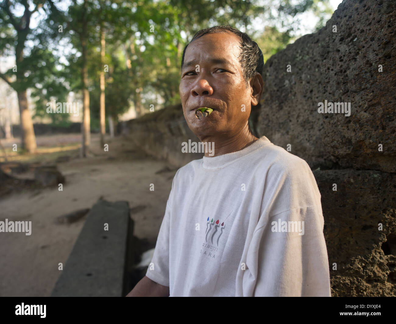 Camobdian uomo di fumare un sigaro in foglia a Prasat Thom il monumento principale di Koh Ker 127 NE di Siem Reap, Cambogia Foto Stock