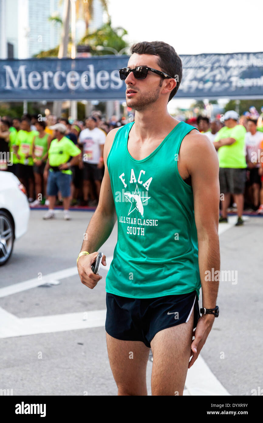 Runner maschio in fase di riscaldamento vicino alla linea di partenza prima dell inizio del 2014 Mercedes-Benz Corporate correre a Miami, Florida, Stati Uniti d'America. Foto Stock