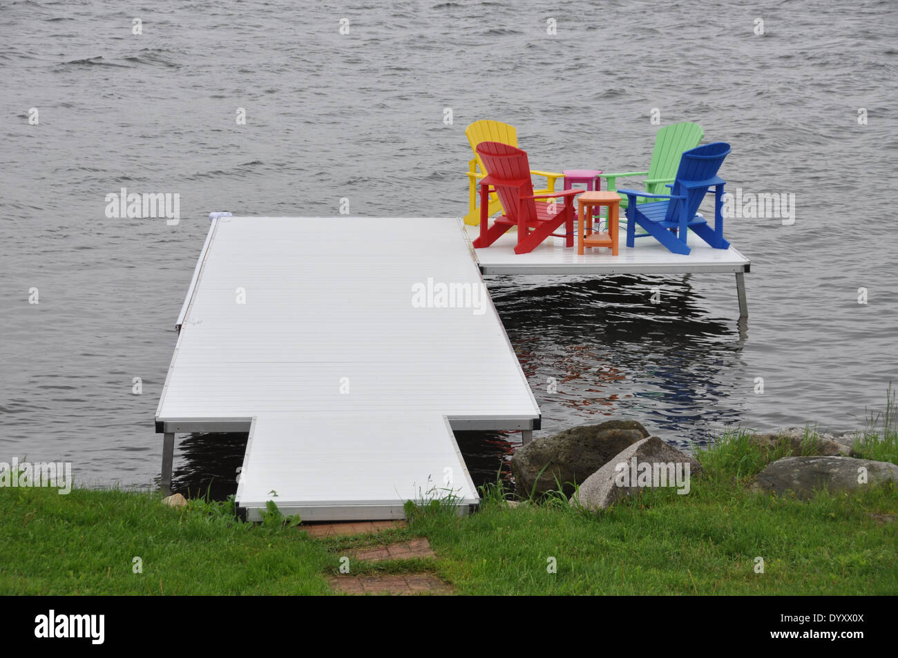 In plastica colorate sedie a sdraio su un piccolo molo sul St Lawrence River, Ontario. Foto Stock