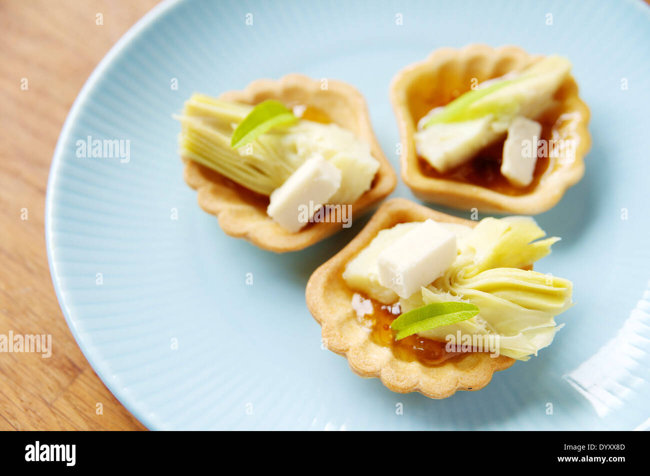 Fig e morsi di carciofi con formaggio Cheddar di soia Foto Stock