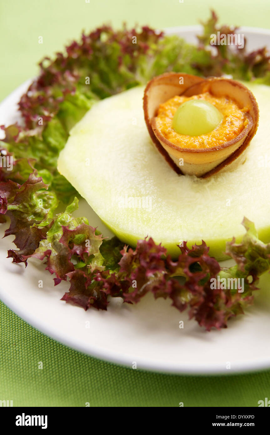 Melone Honeydew con tofu prosciutto e Peperone crema dado Foto Stock