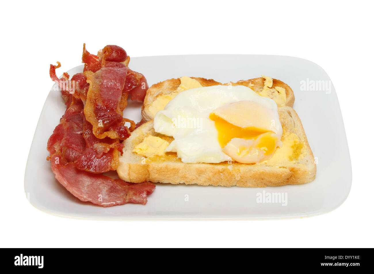 Uovo in camicia su toast con Virga di tuorlo d'uovo e pancetta croccante su una piastra isolata contro bianco Foto Stock