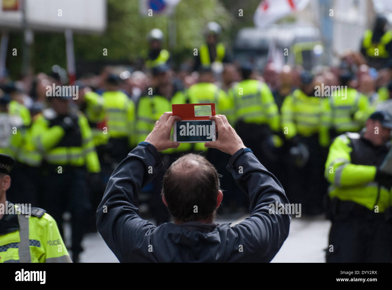 Brighton, Regno Unito. 27 apr 2014. Un uomo utilizza una telecamera-telefono come marzo per Inghilterra sostenitori vengono accompagnati alla stazione dopo la manifestazione annuale sul lungomare di Brighton, Regno Unito. Credito: Peter Manning/Alamy Live News Foto Stock