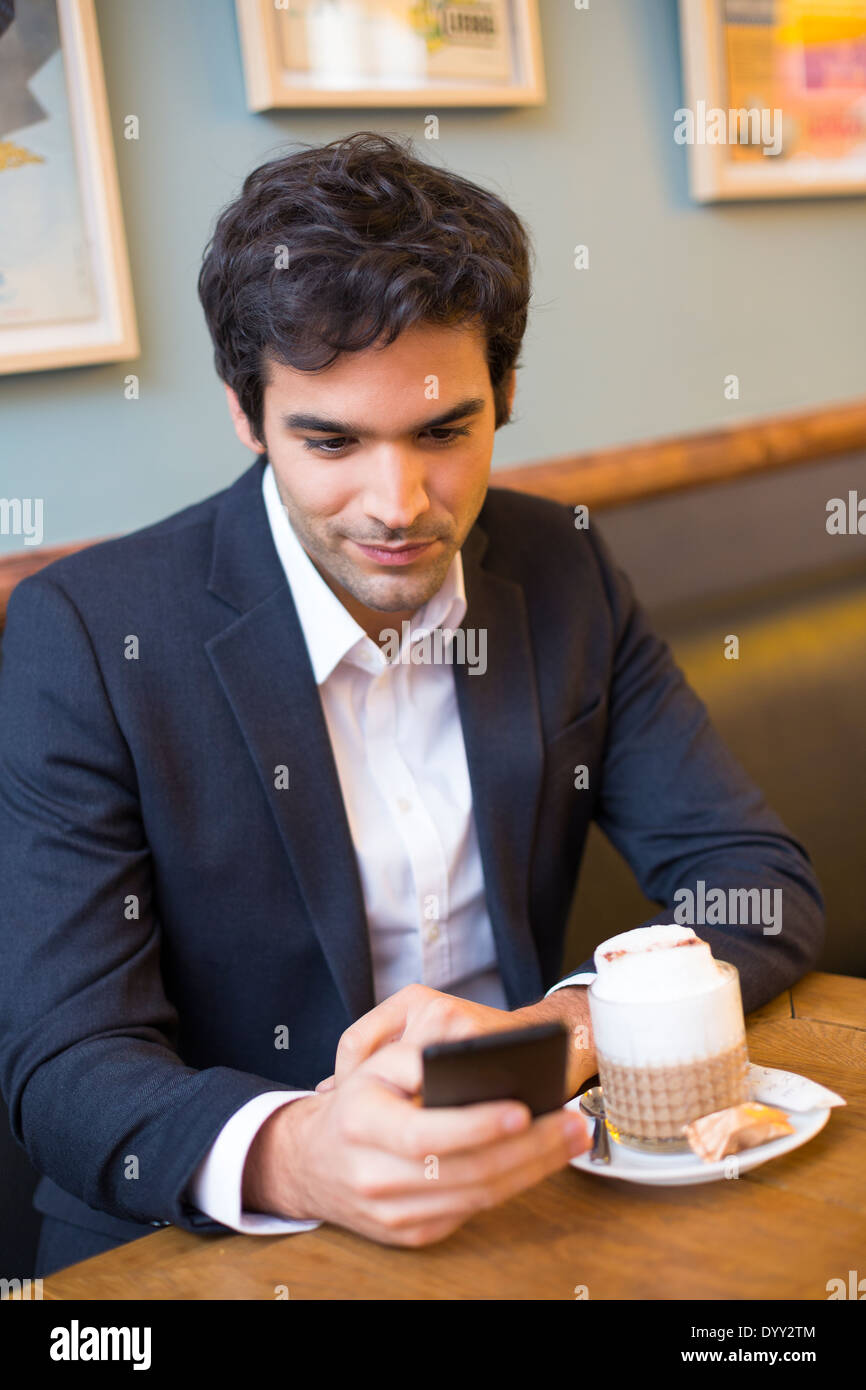 Maschio allegro ristorante cafe smartphone messaggi sms Foto Stock