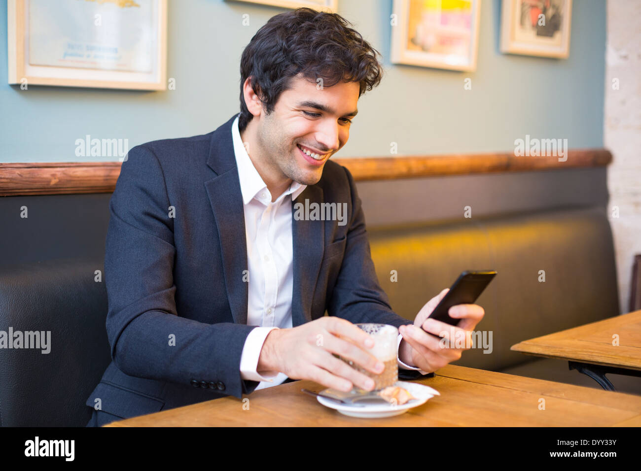 Maschio allegro ristorante cafe smartphone messaggi sms Foto Stock