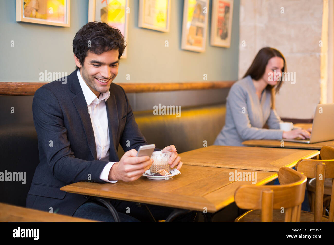 Maschio allegro ristorante cafe smartphone messaggi sms Foto Stock