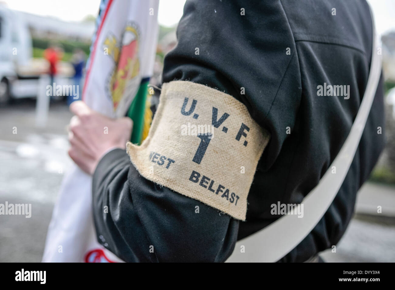 Un uomo che indossa un Ulster Volunteer Force fascia da braccio, e trasporta un flag UVF Foto Stock