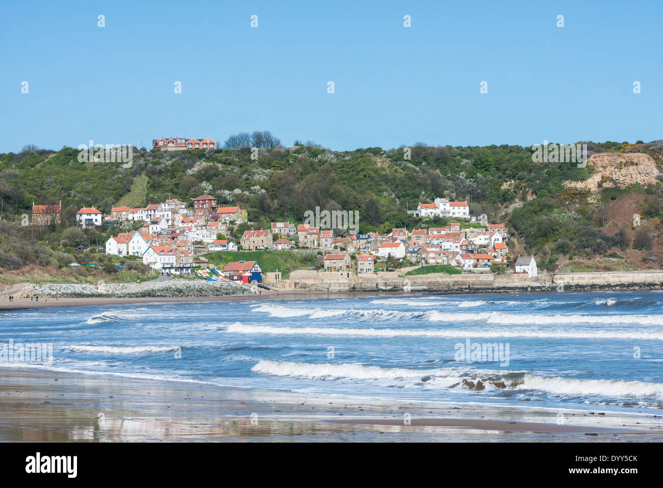 Una vista della baia di Runswick dalla spiaggia con un cielo blu, North Yorkshire, Regno Unito Foto Stock