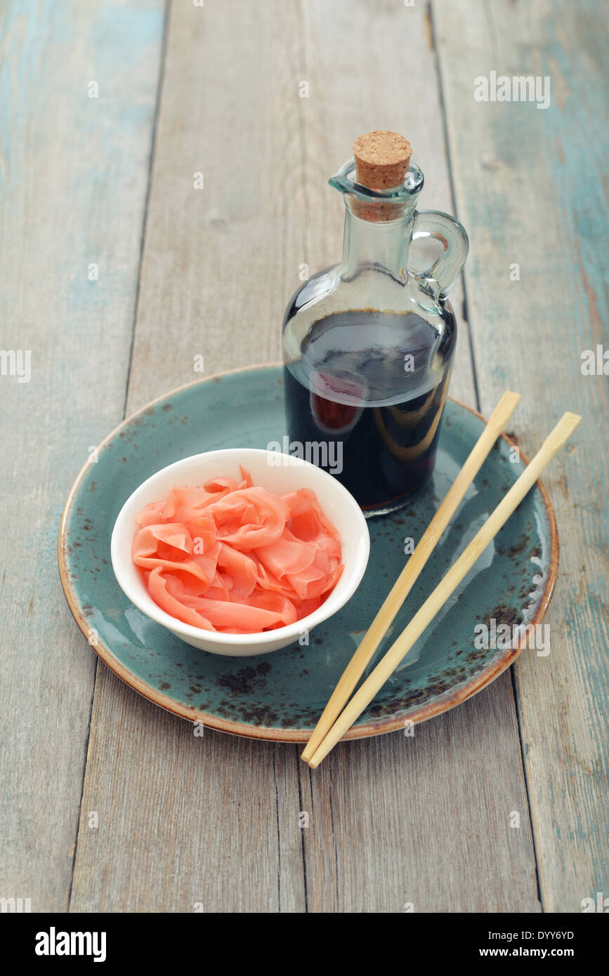 Decapati zenzero con salsa di soia e le bacchette di legno su piastra Foto Stock