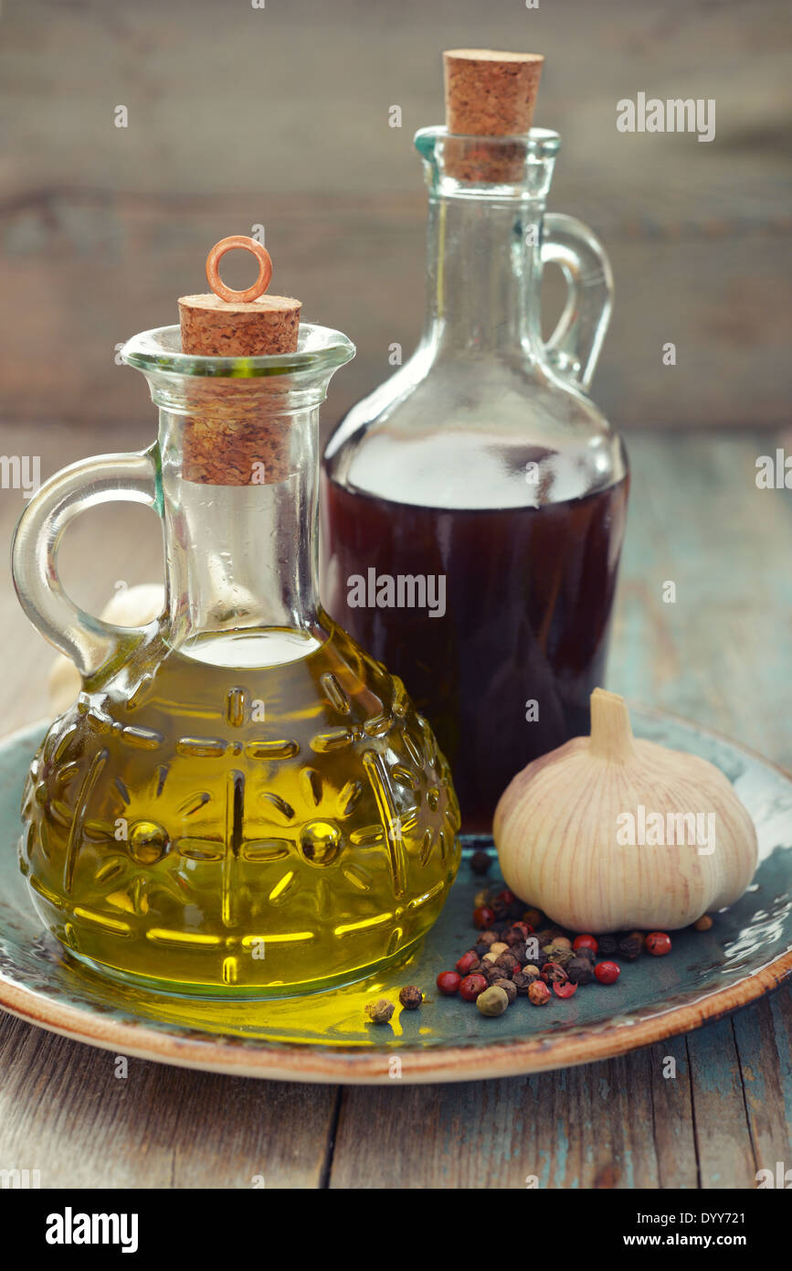 Olio di oliva e aceto di vino in bottiglie su sfondo di legno Foto Stock