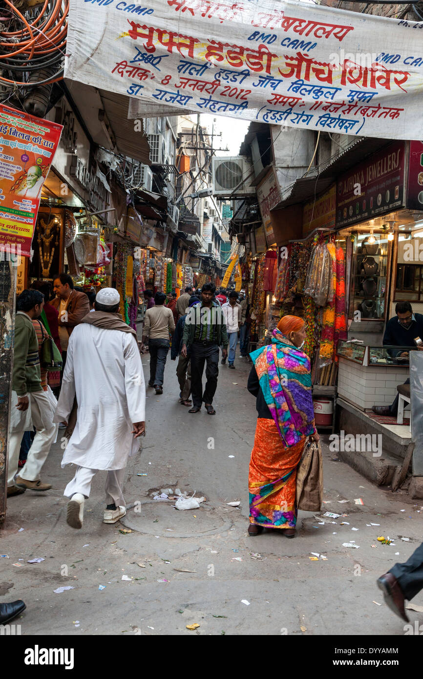 New Delhi, India. Strada stretta in luogo di mercato, Chandni Chowk Area. Script di Devanagari sul tettuccio di banner. Foto Stock