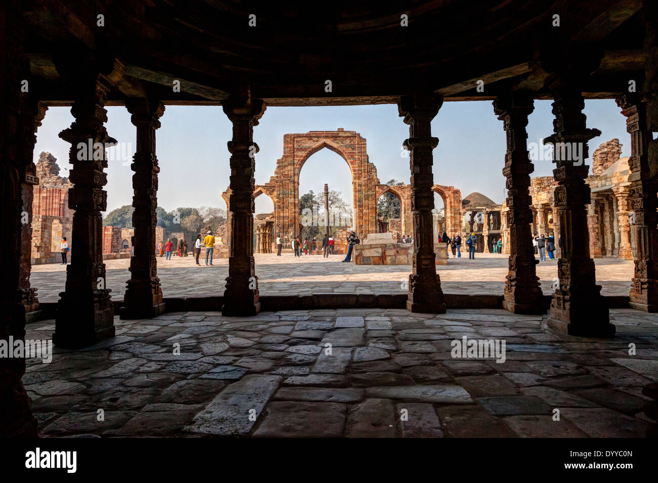 New Delhi, India. Guardando verso la colonna di ferro (4th. Secolo) da Alcova del Quwwat Ul-Islam, la prima moschea in India. Foto Stock