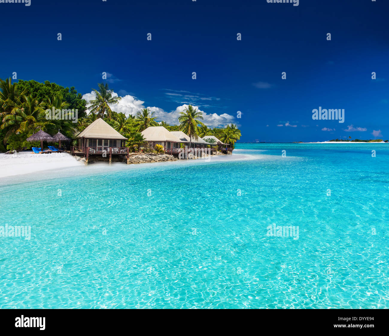 Ville sulla spiaggia sulla piccola isola tropicale con palme Foto Stock