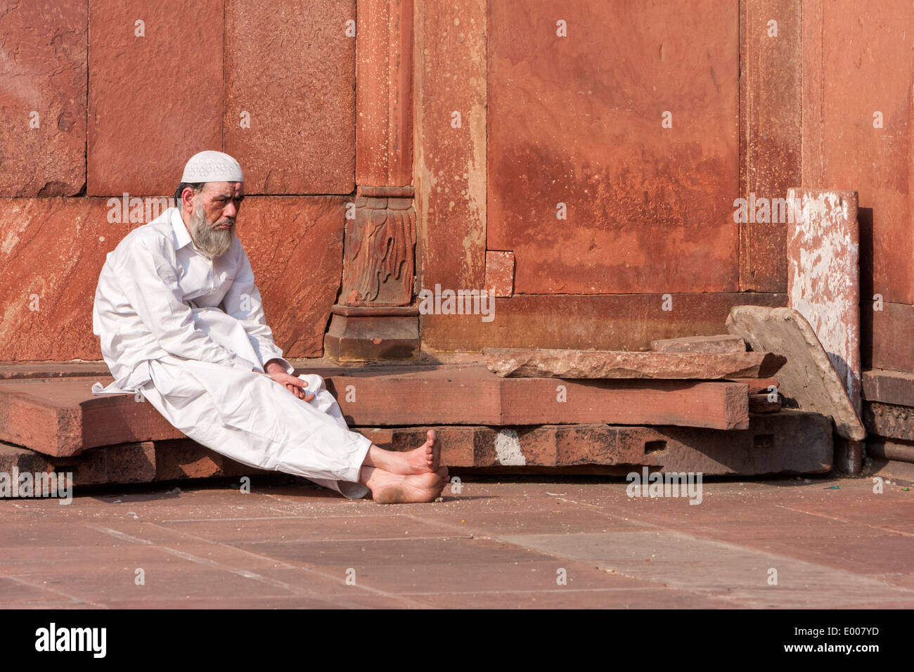 New Delhi, India. Uomo musulmano in attesa per il momento di preghiera presso la Jama Masjid (Moschea del Venerdì). Foto Stock