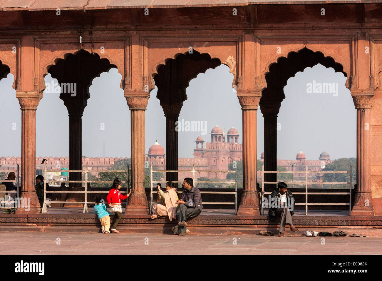 New Delhi, India. Red Fort in background, visto attraverso i portali della Jama Masjid (Moschea del Venerdì). Foto Stock