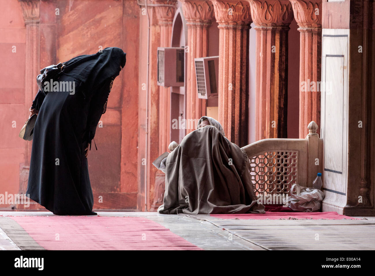New Delhi, India. Donna musulmana a parlare con un mendicante, Jama Masjid (Moschea del Venerdì). Foto Stock