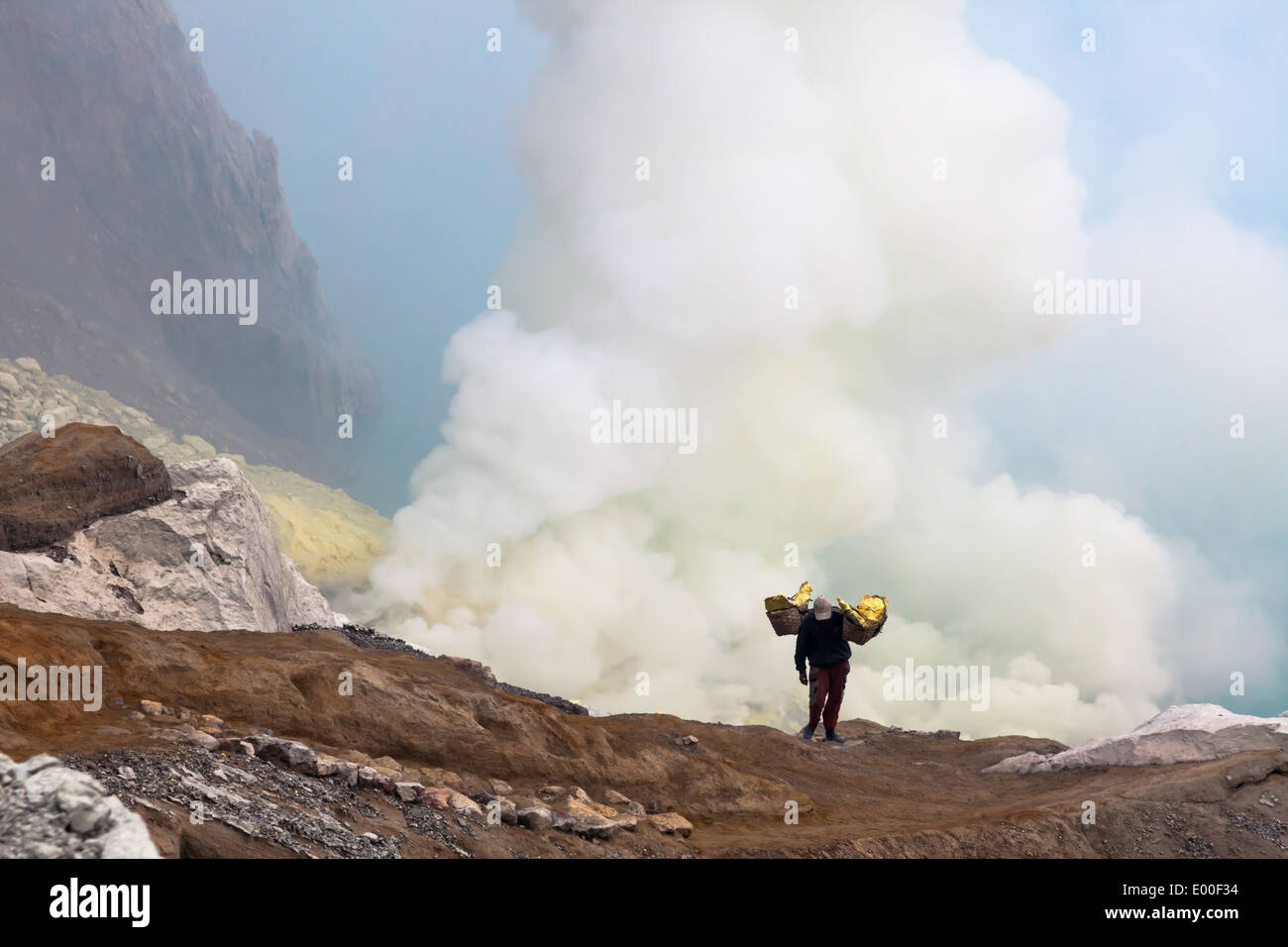 Uomo che porta cestelli laden con blocchi di zolfo, Kawah Ijen, Banyuwangi Regency, East Java, Indonesia Foto Stock