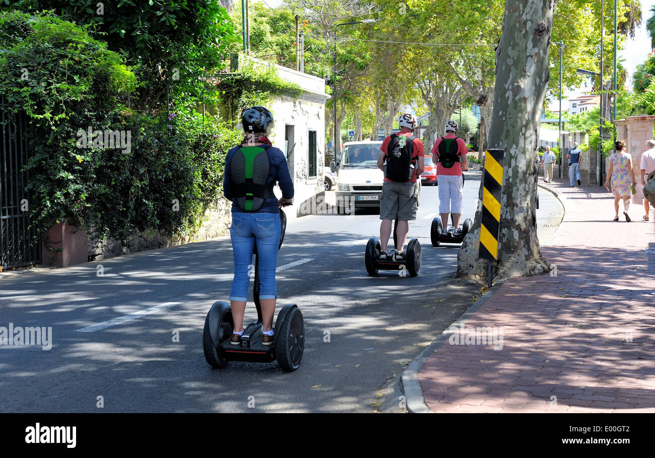 Madeira Portogallo persone a cavallo segways giù per la strada Foto Stock